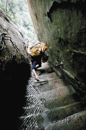 华山第一险道“千尺幢”与地面几乎呈80度，何天武背着60多斤的菜，一只手还要拿着拐杖，只能艰难爬行。
