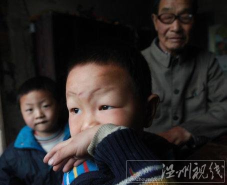 毛坪村的小男孩袁石(中)，告诉记者，他的妹妹袁丽一岁的时候，被抢走了，至今下落不明。他想念妹妹，多次梦到她回家了。 记者 李漠 摄