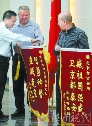 5月13日，故宫博物院负责人来到北京市公安局，向快速侦破故宫失窃案的市局有关部门赠送锦旗。锦旗中的“撼”字应为“捍”。本报记者 贾同军摄 