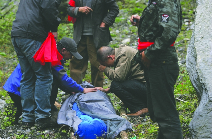 女驴友遇难，警民抬担架遇难者遗体出山