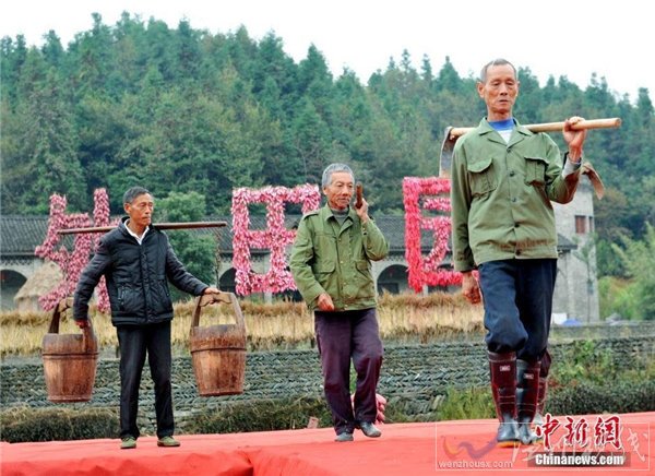大妈们肩挑、手提农具走T台