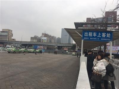火车北站出租车上客处，一边是排起长队的乘客，一边是寥寥可数的出租车。
