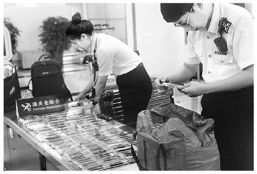 图为海关工作人员在检查旅客携带的假睫毛。王咏洁 摄 