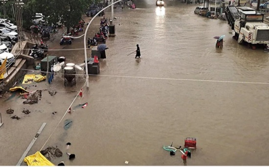 郑州暴雨过后，人们沿着街道趟过洪水。